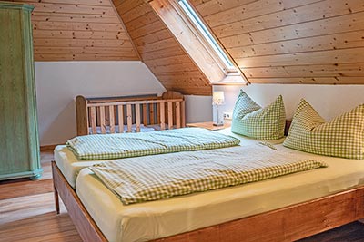 Schlafzimmer mit Doppelbett und Babybett